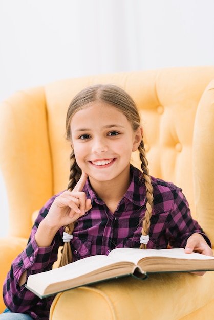 Free photo lovely little girl reading a book