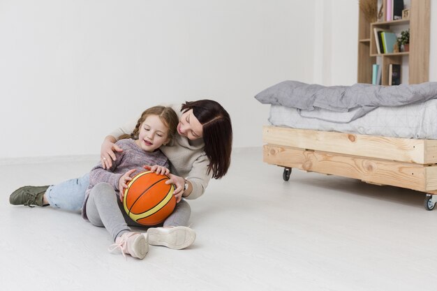 Lovely mom and girl enjoying indoors