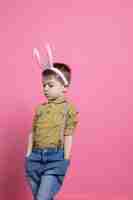 Free photo lovely small boy wearing fluffy bunny ears and posing with confidence