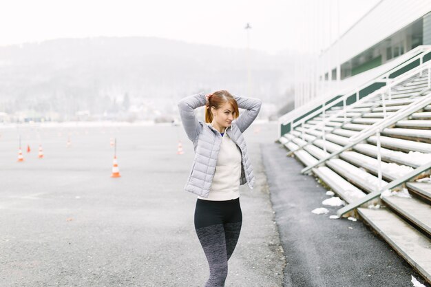 Lovely woman making ponytail during training