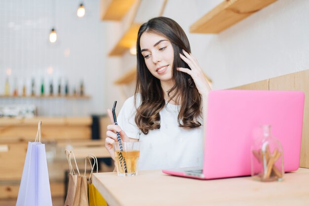 Lovely woman near laptop and paper bags