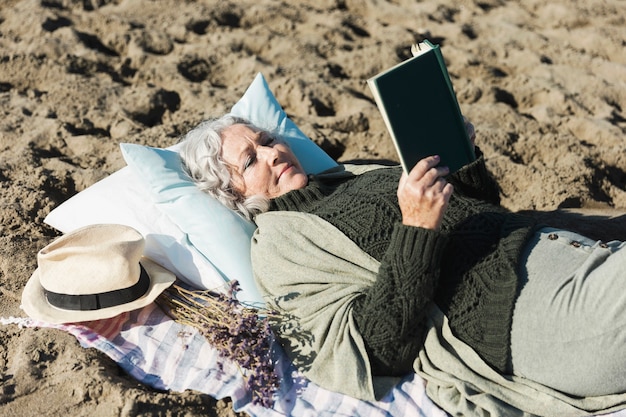 Free photo lovely woman reading book outdoors