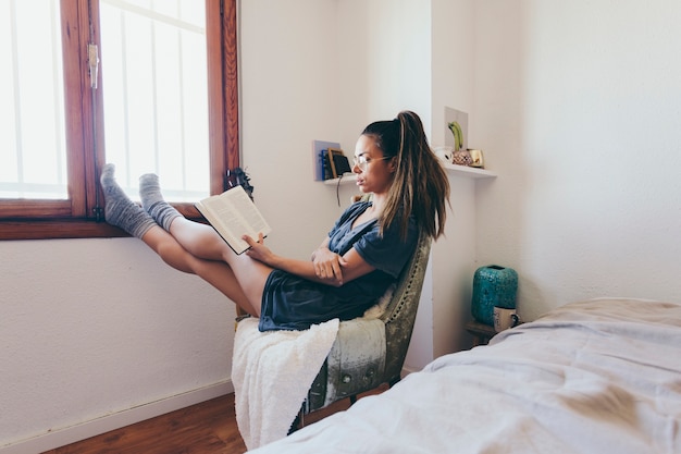 Lovely woman reading near window