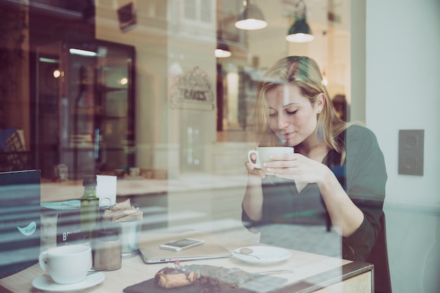 Free photo lovely woman smelling drink in cafe