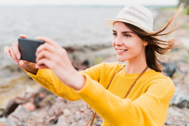 Lovely woman taking a selfie at the sea