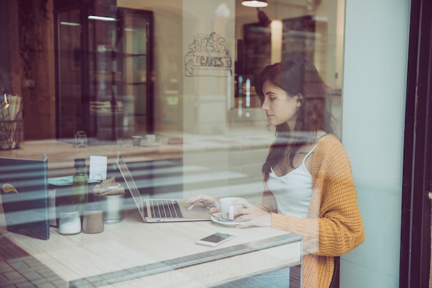 Free photo lovely woman using laptop in cafe