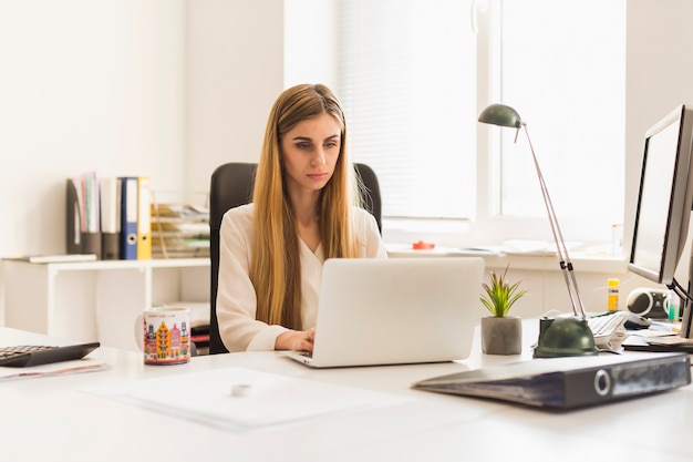 Lovely woman using laptop in office