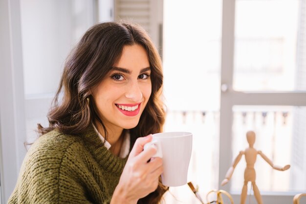 Lovely woman with mug looking at camera