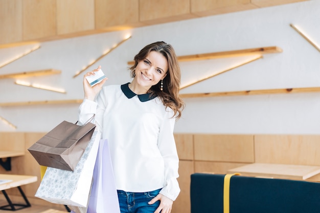 Lovely woman with paper bags and credit card