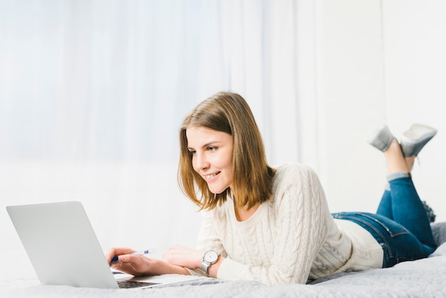 Free Photo lovely woman with pen using laptop