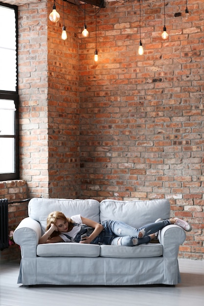 Free photo lovely young woman resting on the couch, interior living room