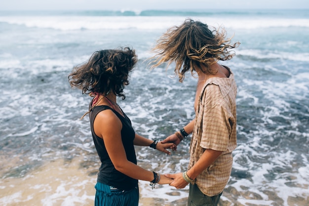 Lovers holding hands and looking at the sea