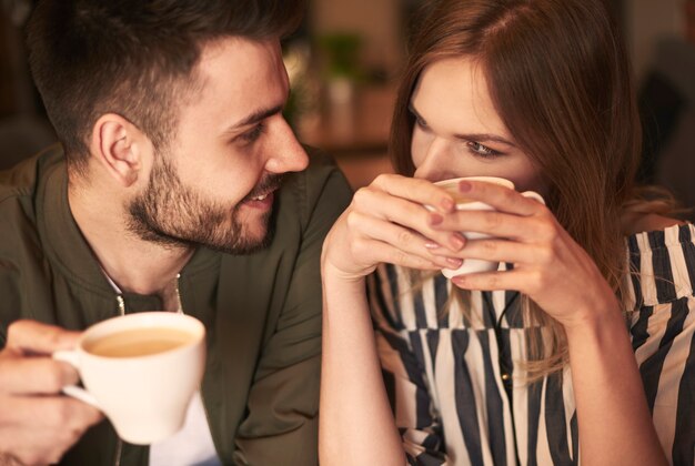 Loving couple having hot drinks