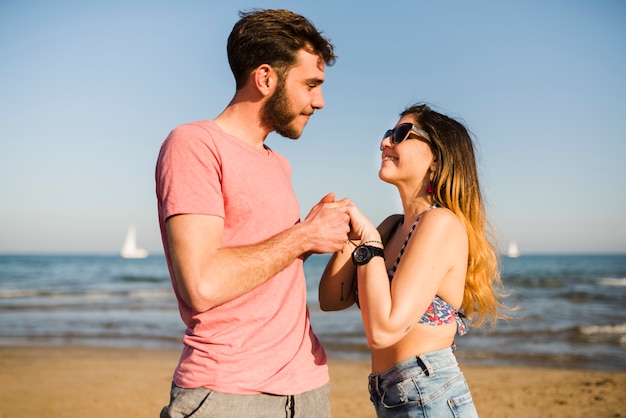 Loving couple holding each other's hand standing at beach