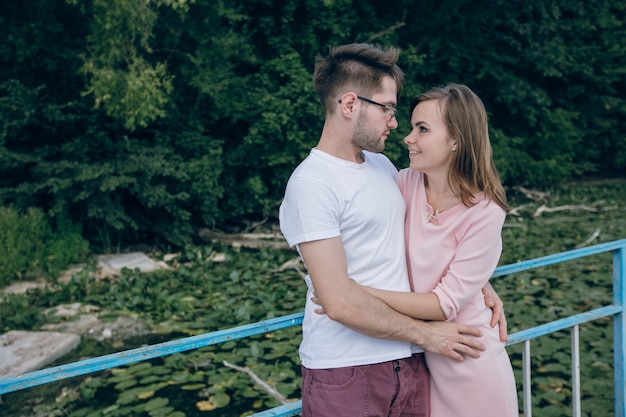 Loving couple looking into each other's eyes on a bridge