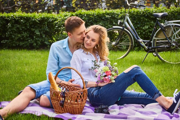 Loving couple at a picnic after bicycle ride in a park.