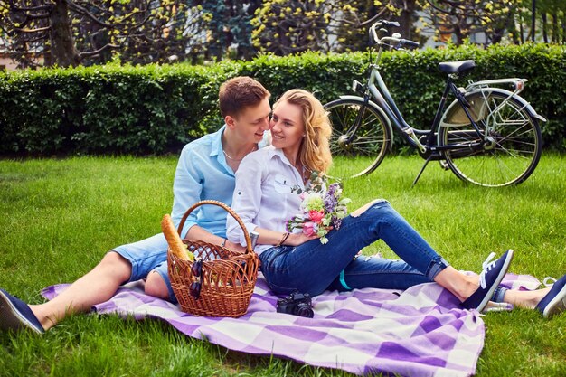 Loving couple at a picnic after bicycle ride in a park.