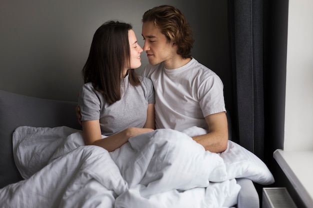 Loving couple posing in bed