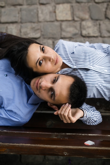 Free photo loving couple posing on bench