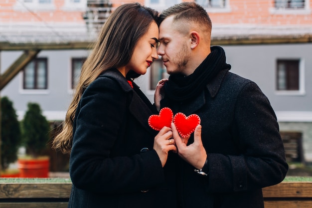 Free Photo loving couple posing with red hearts