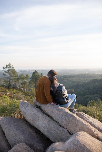 Free Photo loving couple resting after hiking in autumn. man and woman in casual clothes with hiking ammunition sitting at peak, leaning on shoulder. nature, activity, hobby concept