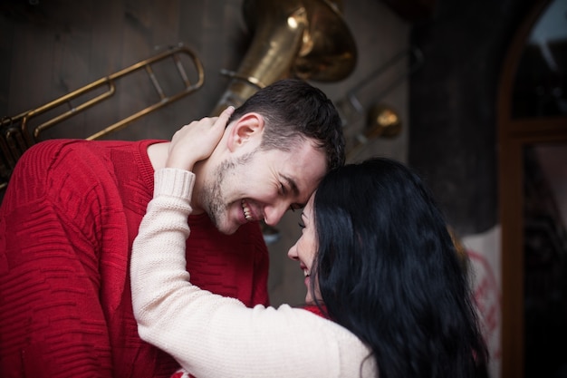 Free photo loving couple in sweaters posing inside