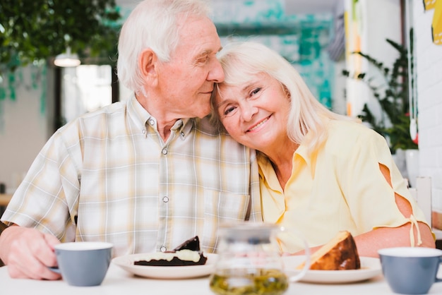 Loving elderly couple drinking tea with cake