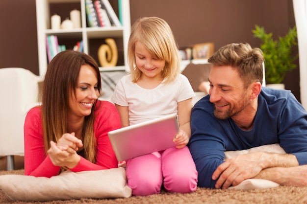 Free photo loving family using digital tablet on carpet