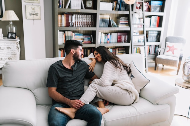 Loving man and sitting with her boyfriend on white sofa at home