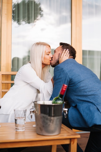 Free Photo loving young couple kissing together at restaurant