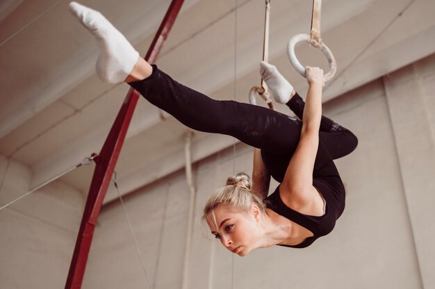 Low angle athletic woman training on gymnastics rings