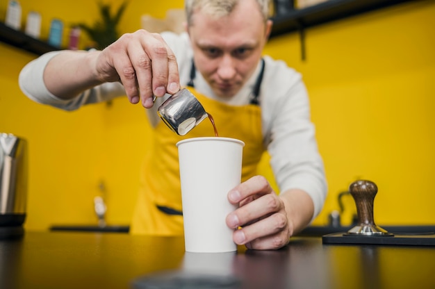 Free Photo low angle of barista pouring coffee