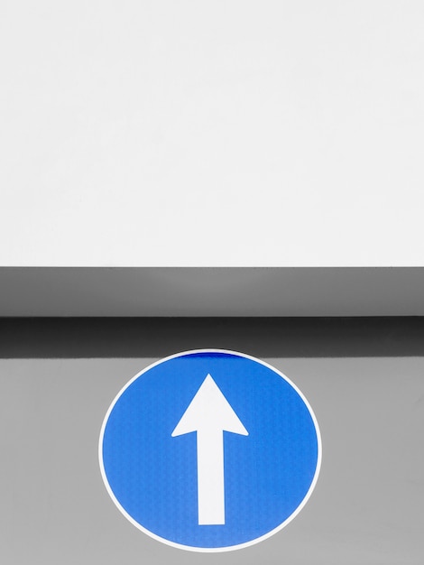 Free Photo low angle of blue sign with arrow and copy space