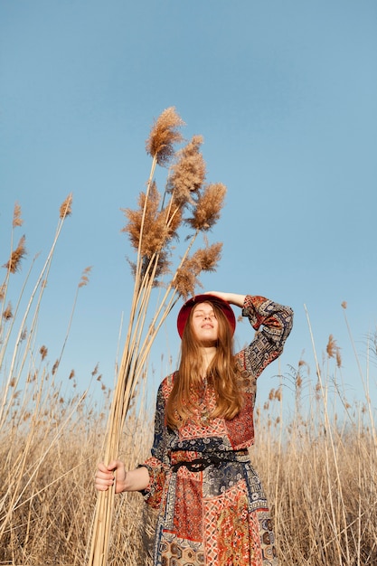 Free Photo low angle of bohemian woman posing in nature