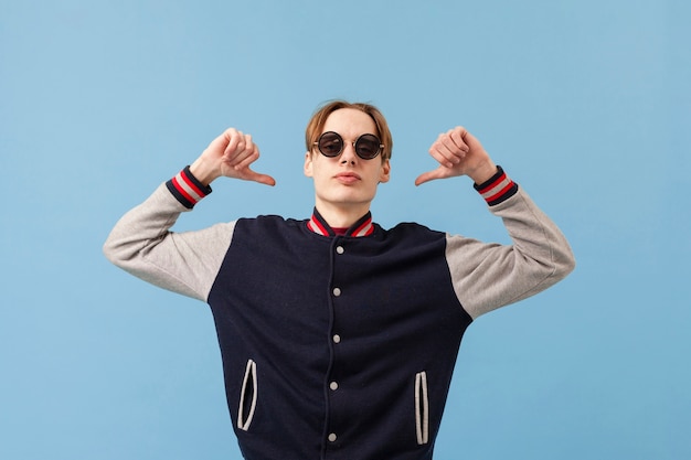 Free photo low angle boy pointing at himself