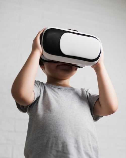 Free photo low angle boy watching virtual reality