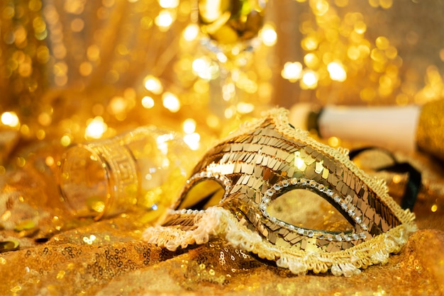 Low angle of a carnival mask and a glass with coins