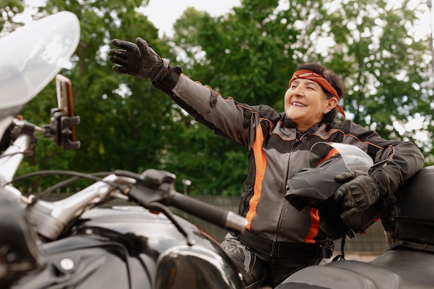 Free photo low angle cool old woman with motorcycle