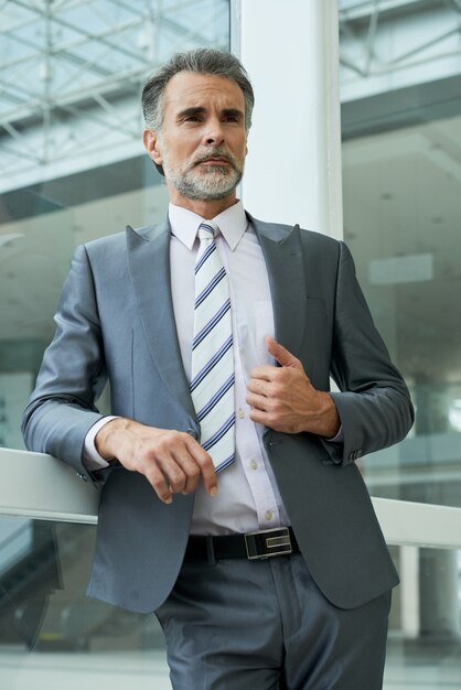 Low angle of elegant businessman standing in the office building