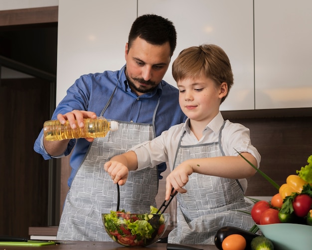 Low angle father and son making salad