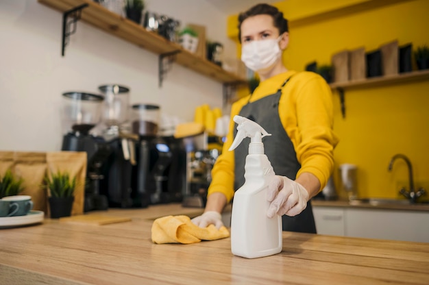 Low angle of female barista with medical mask