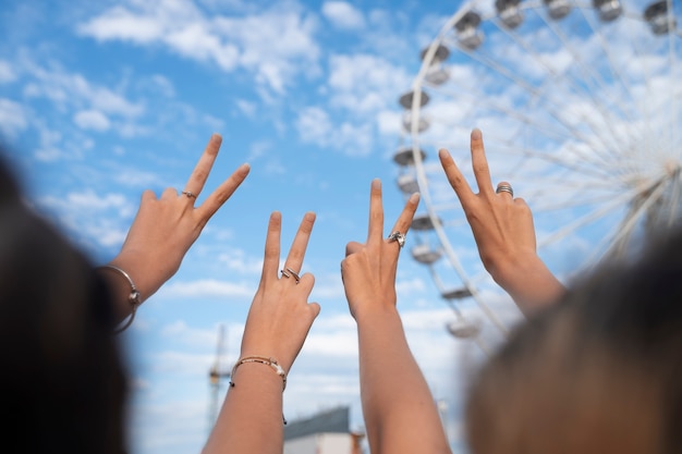 Free photo low angle friends making hand gestures