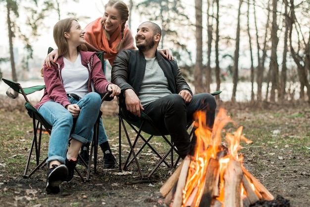 Low angle friends sitting at bonfire