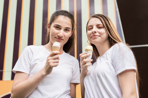 Free photo low angle friends with ice cream looking at camera