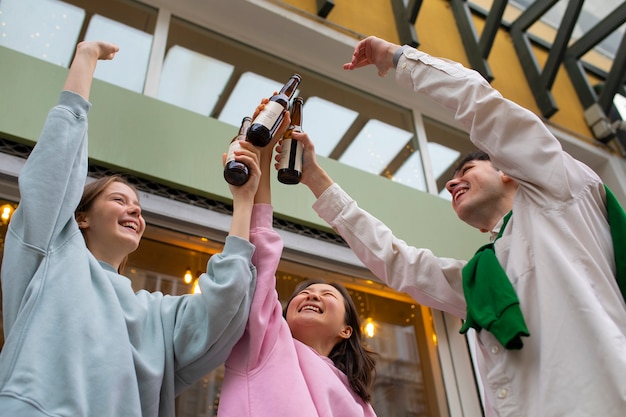 Free photo low angle friends with kombucha bottles