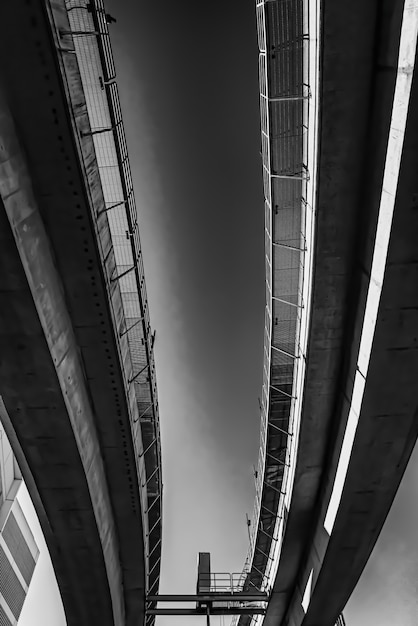 Free Photo low angle greyscale of a concrete bridge under the sunlight at daytime