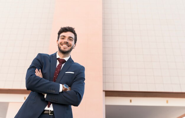 Low angle happy man in suit posing