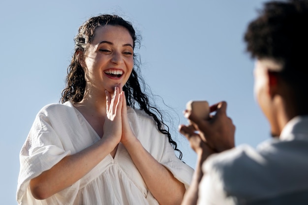 Low angle happy woman accepting proposal