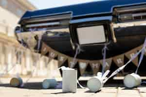 Free photo low angle just married scene with car and cans