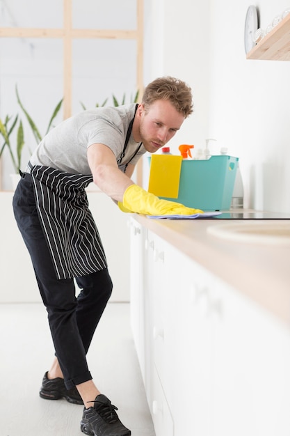 Low angle man cleaning kitchen